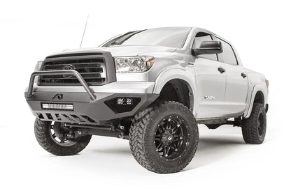 Fab Fours Vengeance front bumper with pre-runner guard on a silver Toyota Tundra, front three-quarter view from the driver side, showing the pre-runner hoop, the LED light bar, cube lights and skid plate