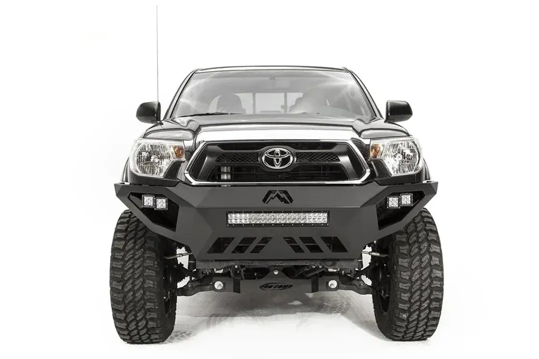 Fab Fours Vengeance front bumper on a gray Toyota Tacoma, front view, showing the LED light bar, cube lights and skid plate