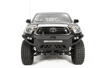 Fab Fours Vengeance front bumper on a gray Toyota Tacoma, front view, showing the LED light bar, cube lights and skid plate