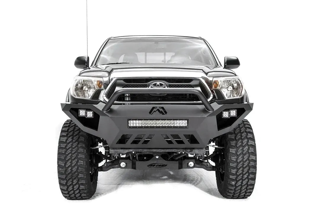 Fab Fours Vengeance front bumper with high pre-runner guard on a gray Toyota Tacoma, front view, showing the high pre-runner hoop, LED light bar, cube lights and skid plate