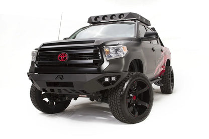 Fab Fours Vengeance front bumper on a matte black Toyota Tundra, front three-quarter view from the driver side, showing the LED cube lights, angled end caps and skid plate