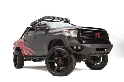 Fab Fours Vengeance front bumper on a matte black Toyota Tundra, front three-quarter view from the passenger side, showing the LED cube lights, angled end caps and skid plate