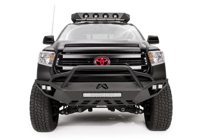 Fab Fours Vengeance front bumper with pre-runner guard on a matte black Toyota Tundra, front view, showing the pre-runner hoop, LED light bar, cube lights and skid plate