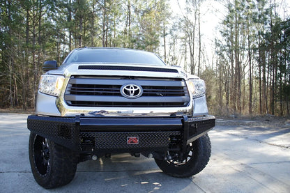 Fab Fours Black Steel front bumper on a silver Toyota Tundra, straight-on front view outdoors, showing the no-guard design, diamond-plate face, and tubular top bar