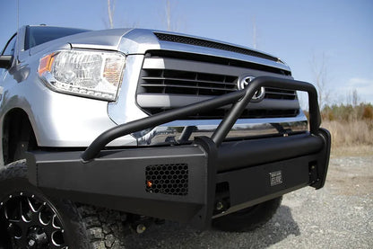 Fab Fours Black Steel Elite front bumper with pre-runner guard on a silver Toyota Tundra, close front three-quarter view outdoors, showing the pre-runner hoop, mesh light opening, and Elite badge