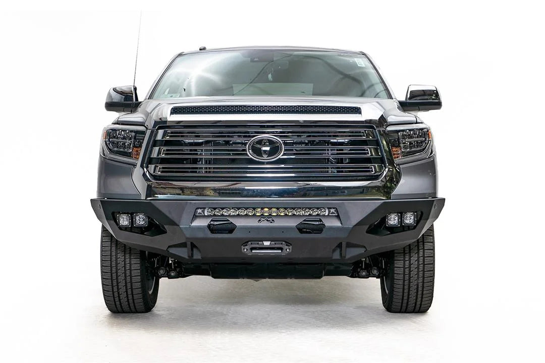 Fab Fours Matrix front bumper on a gray Toyota Tundra, straight-on front view, showing the center winch mount, LED light bar, and cube light pods