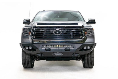 Fab Fours Matrix front bumper on a gray Toyota Tundra, straight-on front view, showing the center winch mount, LED light bar, and cube light pods