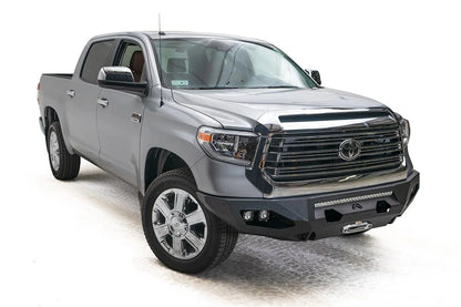 Fab Fours Matrix front bumper on a gray Toyota Tundra, front three-quarter view, showing the no-guard design, light bar opening, and cube light pods