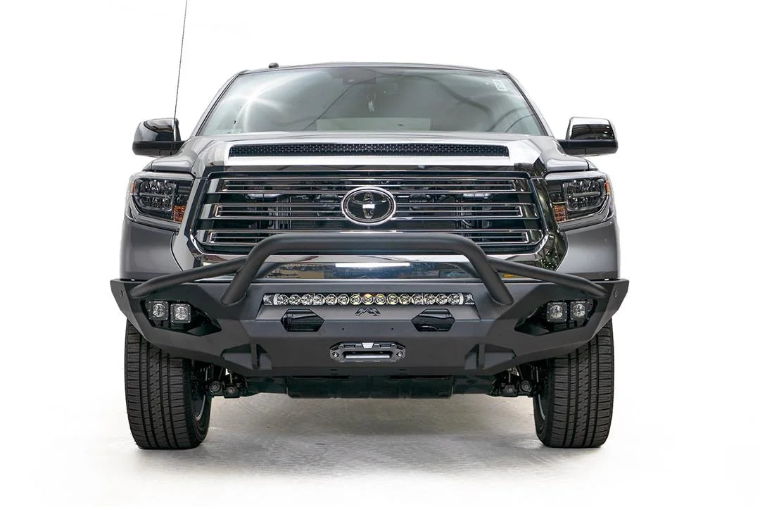 Fab Fours Matrix front bumper with pre-runner guard on a gray Toyota Tundra, straight-on front view, showing the pre-runner hoop, LED light bar, and center winch mount