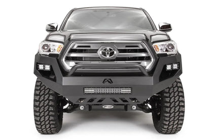 Fab Fours Vengeance front bumper with low pre-runner guard on a dark gray Toyota Tacoma, straight-on front view, showing the low guard hoop, LED light bar, and cube light pods
