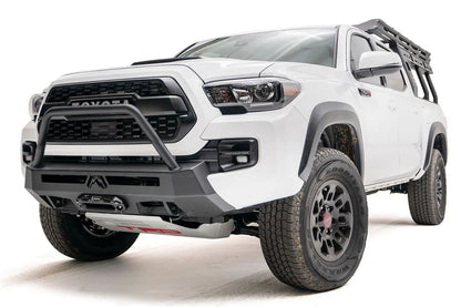 Fab Fours Hidden Winch Mount with high pre-runner guard on a white Toyota Tacoma, front three-quarter view, showing the guard hoop, winch fairlead, and low-profile winch plate