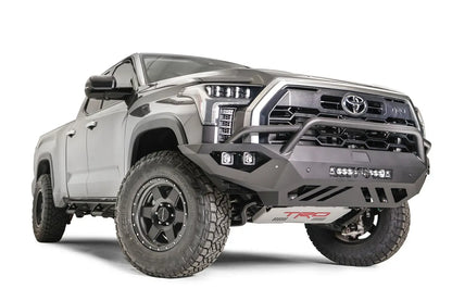 Fab Fours Vengeance front bumper with pre-runner guard on a gray Toyota Tundra, elevated front three-quarter view, showing the pre-runner hoop, LED light bar, and cube light pods