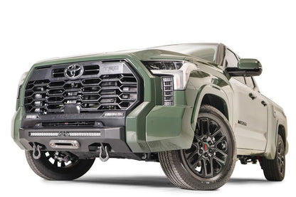 Fab Fours Hidden Winch Mount on a green Toyota Tundra, front three-quarter view, showing the winch fairlead, LED light bar, and D-ring shackles