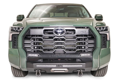 Fab Fours Hidden Winch Mount on a green Toyota Tundra, straight-on front view, showing the hidden winch fairlead, LED light bar, and D-ring shackles