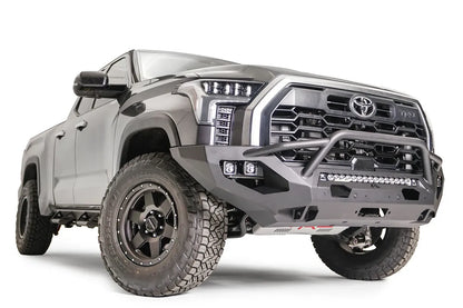Fab Fours Matrix front bumper with pre-runner guard on a gray Toyota Tundra, front three-quarter view, showing the pre-runner hoop, LED light bar, and cube light pods