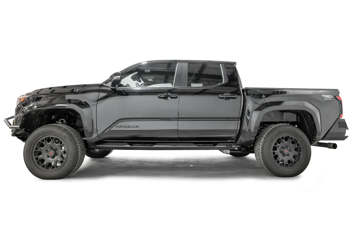 Fab Fours step slider on a black four-door Toyota Tacoma TRD Sport, driver-side profile