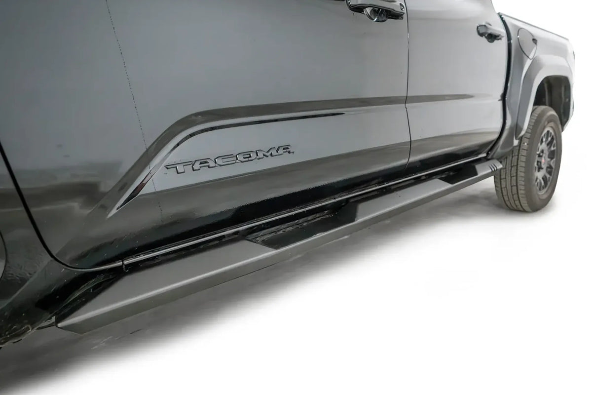 Fab Fours step slider on a black Toyota Tacoma, passenger-side view along the rocker