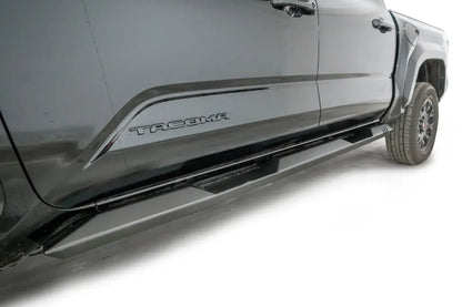 Fab Fours step slider on a black Toyota Tacoma, passenger-side view along the rocker