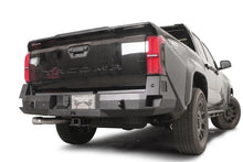 Fab Fours Premium rear sensor bumper on a dark gray Toyota Tacoma, rear three-quarter view, showing the sensor-ready face, recessed lights, and angled end caps
