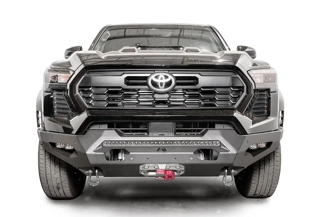 Fab Fours Matrix front bumper on a dark gray Toyota Tacoma, straight-on front view, showing the full-width bumper, LED light bar, and center winch