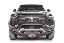 Fab Fours Matrix front bumper with pre-runner guard on a black Toyota Tacoma, straight-on front view, showing the pre-runner hoop, LED light bar, and center winch