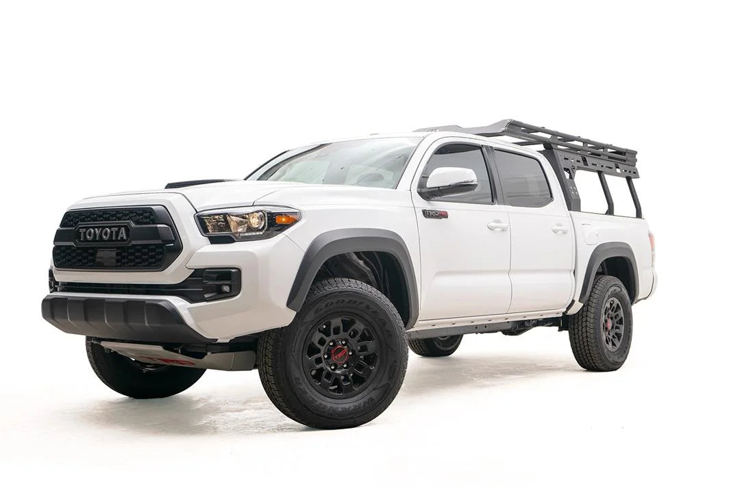 Fab Fours Overland Rack on a white Toyota Tacoma TRD Pro, front driver-side view, with the low-profile rack mounted over the bed behind the cab