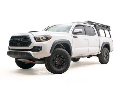 Fab Fours Overland Rack on a white Toyota Tacoma TRD Pro, front driver-side view, with the low-profile rack mounted over the bed behind the cab