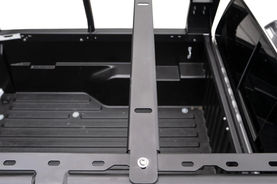 Fab Fours overland rack additional crossmember bolted across the rack rails over the bed of a Toyota Tacoma, top-down view