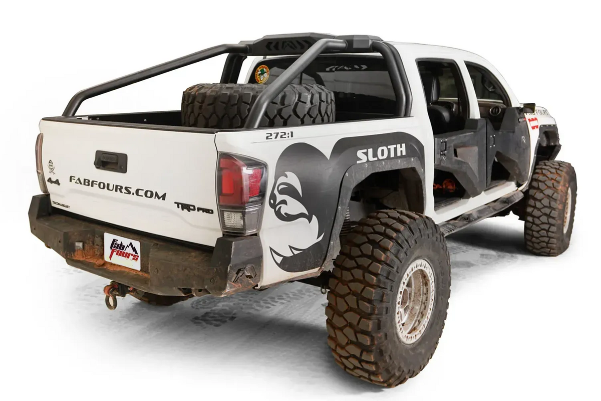 Fab Fours sport rack on a lifted white Toyota Tacoma TRD Pro with spare tire in the bed, passenger-side rear three-quarter view, with Fab Fours rear bumper