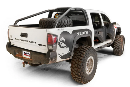 Fab Fours sport rack on a lifted white Toyota Tacoma TRD Pro with spare tire in the bed, passenger-side rear three-quarter view, with Fab Fours rear bumper