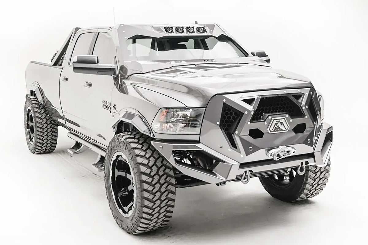 Fab Fours ViCowl on a silver Ram 2500, front three-quarter view, showing the windshield frame cover, integrated roof light pods, and cowl-to-hood fit