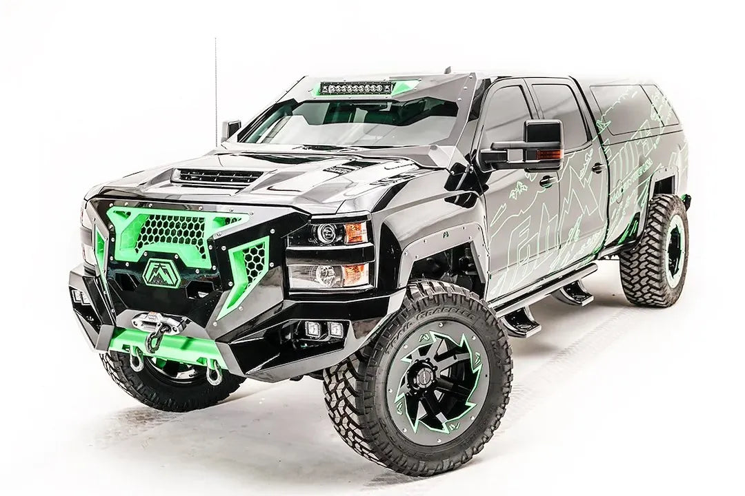 Fab Fours ViCowl on a black and green wrapped Chevrolet Silverado 2500 HD, front three-quarter view, showing the windshield frame cover, LED light bar, and A-pillar wrap