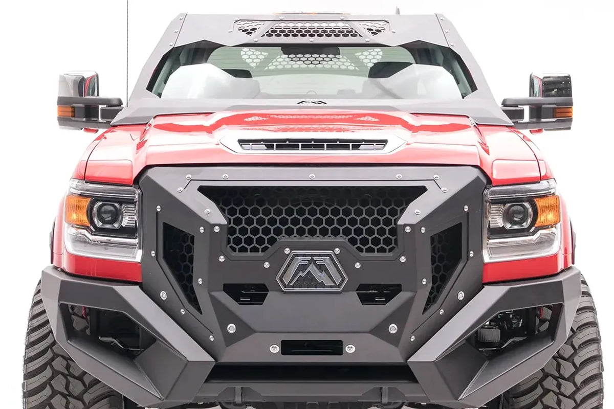 Fab Fours ViCowl on a lifted red GMC Sierra HD, front view, with the steel windshield cowl above a matching Fab Fours front bumper and honeycomb grille guard