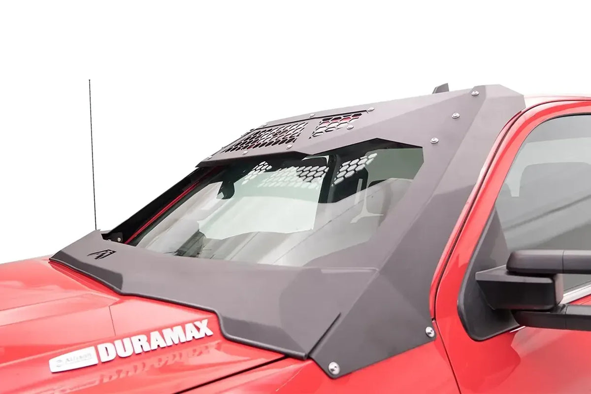 Fab Fours ViCowl on a red GMC Sierra 2500 HD Duramax, driver-side view, showing the matte black steel cowl and roof visor with honeycomb vent panels framing the windshield