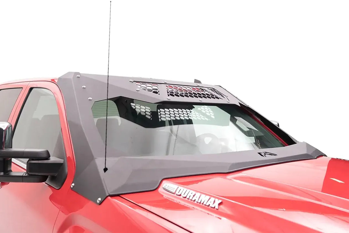 Fab Fours ViCowl on a red GMC Sierra 2500 HD, passenger-side view, showing the bolted steel A-pillar cover, honeycomb visor panels and retained factory antenna