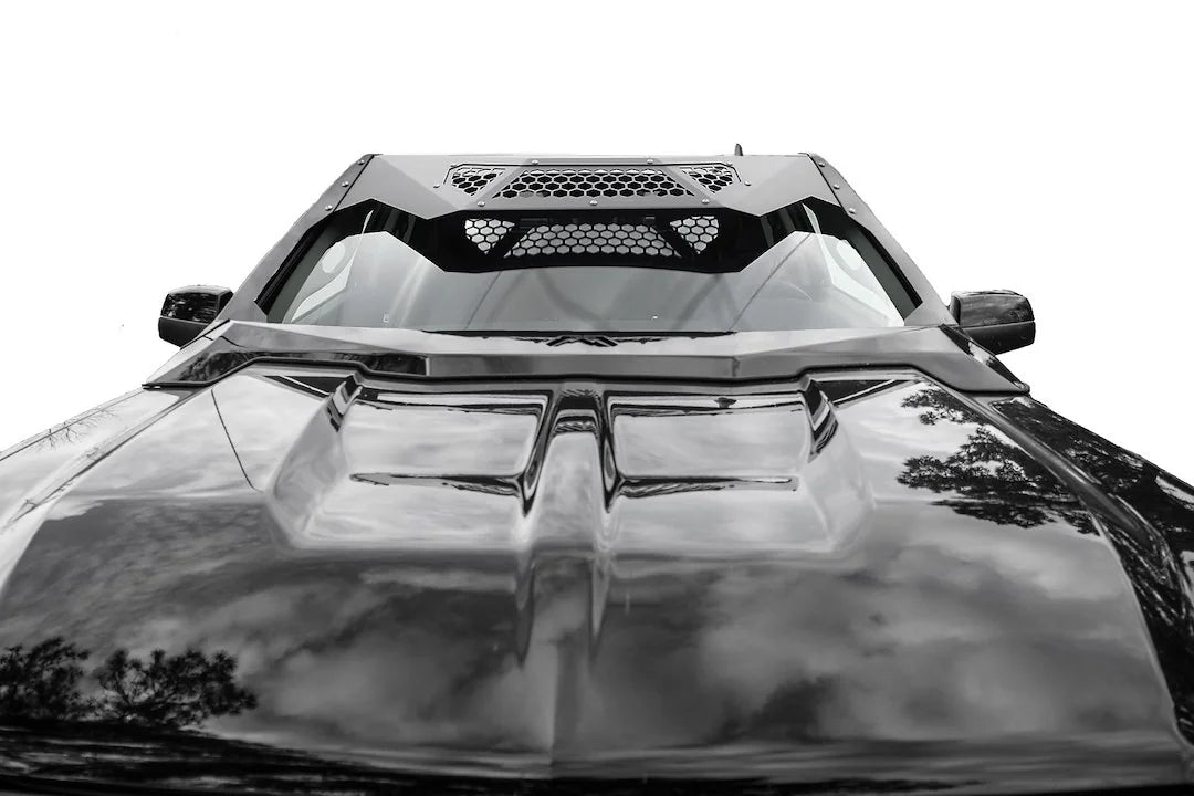 Fab Fours ViCowl on a black Chevrolet Silverado 1500, close-up over the hood, showing the windshield frame cover, honeycomb mesh vent, and cowl edge