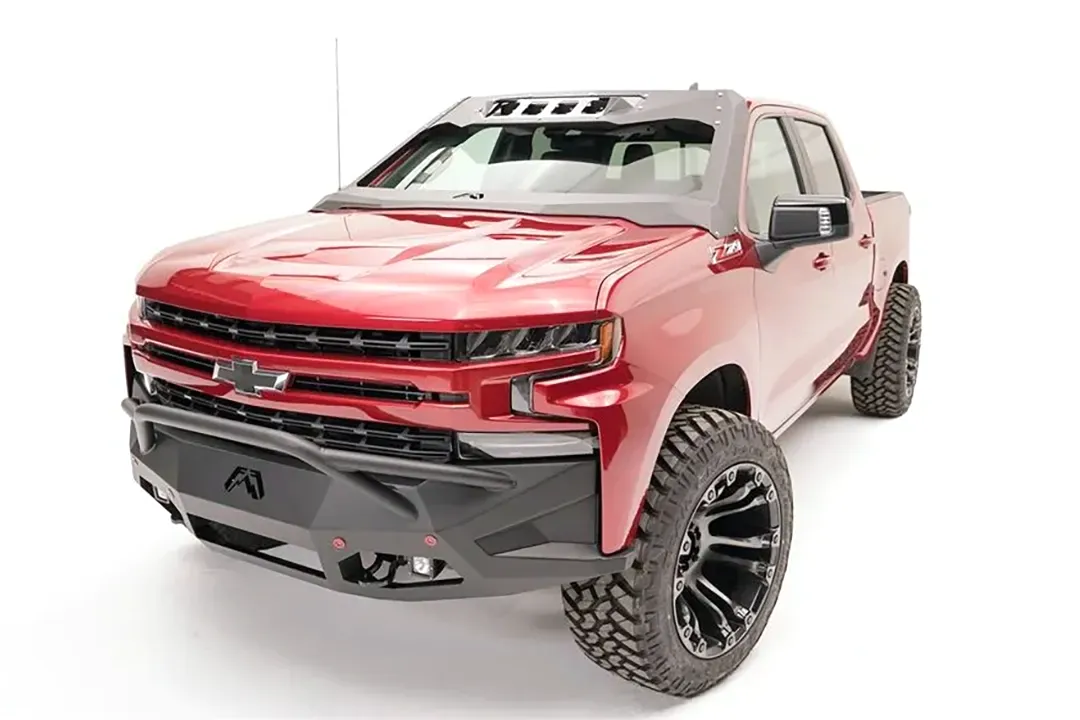 Fab Fours ViCowl on a red Chevrolet Silverado 1500, front three-quarter view, showing the windshield frame cover, light pods, and A-pillar wrap