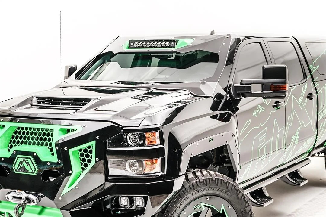 Fab Fours ViCowl 20-inch light bar insert on a black Chevrolet Silverado HD with green accents, front driver-side view, showing the light bar mounted at the top of the ViCowl windshield frame