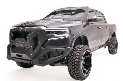Fab Fours ViCowl on a lifted gray Ram 1500, front driver-side view, with the steel windshield cowl and honeycomb visor above a matching Fab Fours front bumper and grille guard