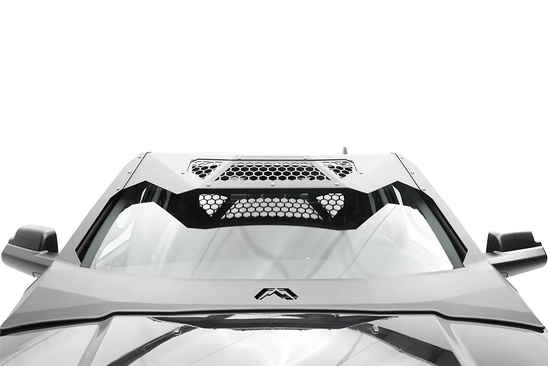Fab Fours ViCowl on a silver Ram 2500, close-up over the hood, showing the windshield frame cover, honeycomb mesh vent, and logo badge