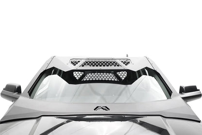 Fab Fours ViCowl on a silver Ram 2500, close-up over the hood, showing the windshield frame cover, honeycomb mesh vent, and logo badge