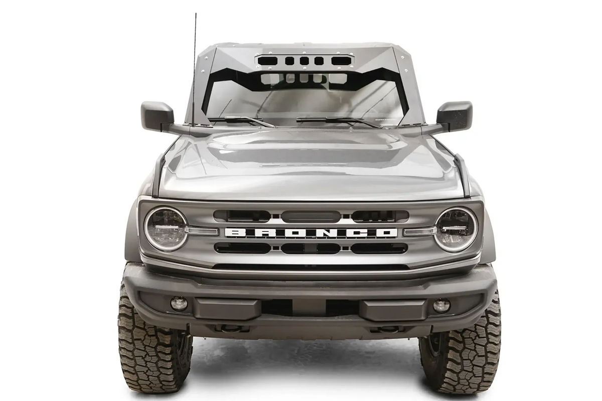 Fab Fours ViCowl on a gray Ford Bronco, front view, showing the matte black steel cowl with slotted visor cutouts framing the windshield