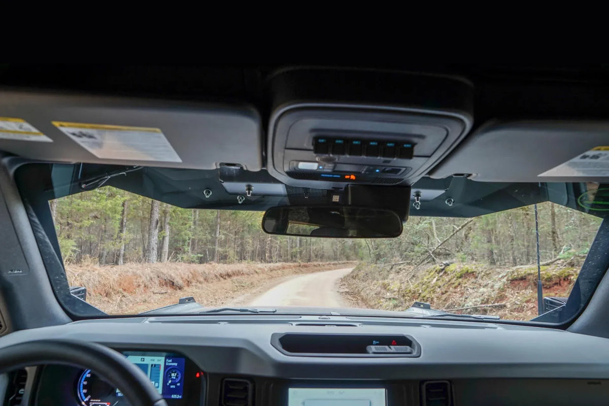 Driver's view from inside a Ford Bronco with the Fab Fours ViCowl installed, showing the low steel visor edge and clear view of the trail ahead