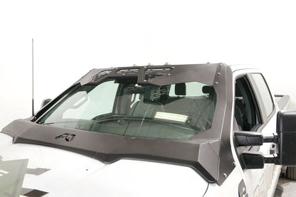 Fab Fours ViCowl Windshield Protection on a white Ford Super Duty, angled driver-side view, showing the matte black steel cowl with vented light pod panels, A-pillar covers and Fab Fours logo