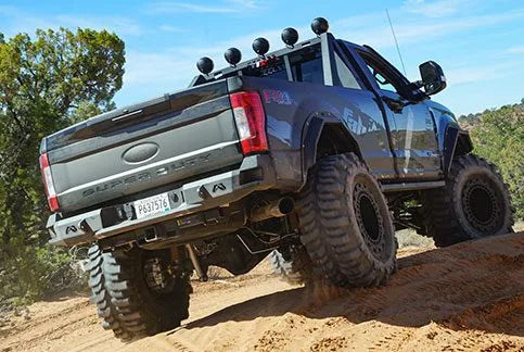 Daylighter Ford Super Duty rear bumper and light bar climbing a rock obstacle near Moab