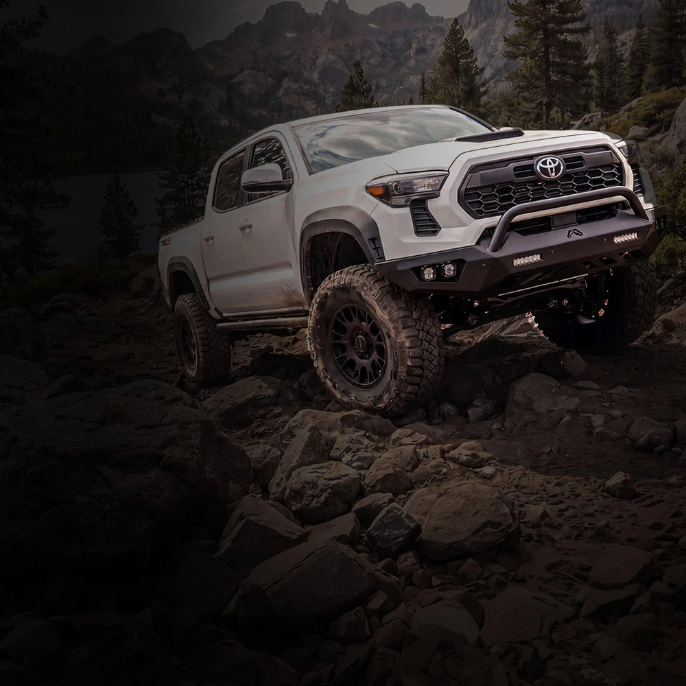 White truck with Fab Fours SmartSteel bumper on rocky terrain
