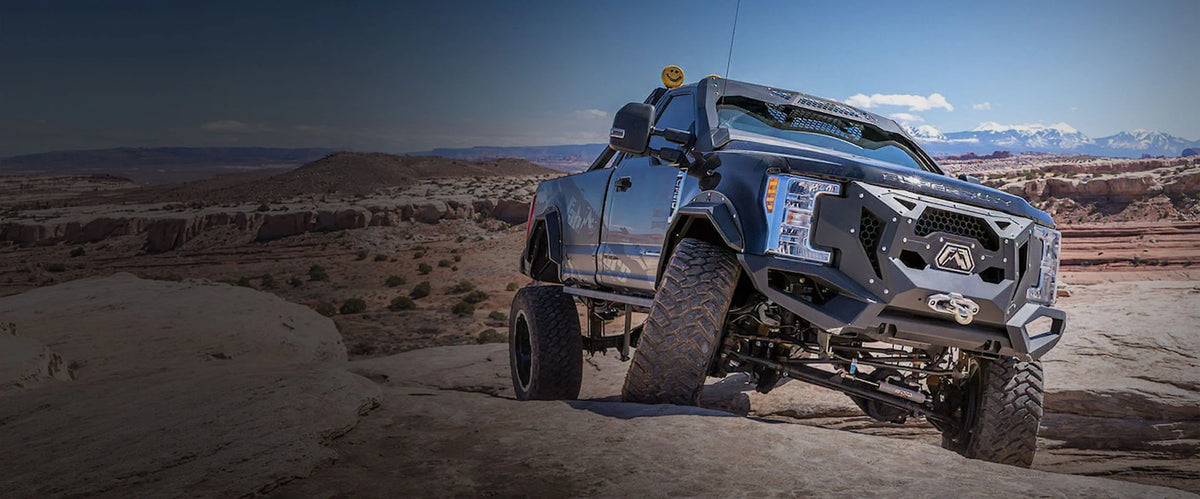 Custom Fab Fours Ford F-350 Daylighter bumper off-roading in sand dunes, hero image